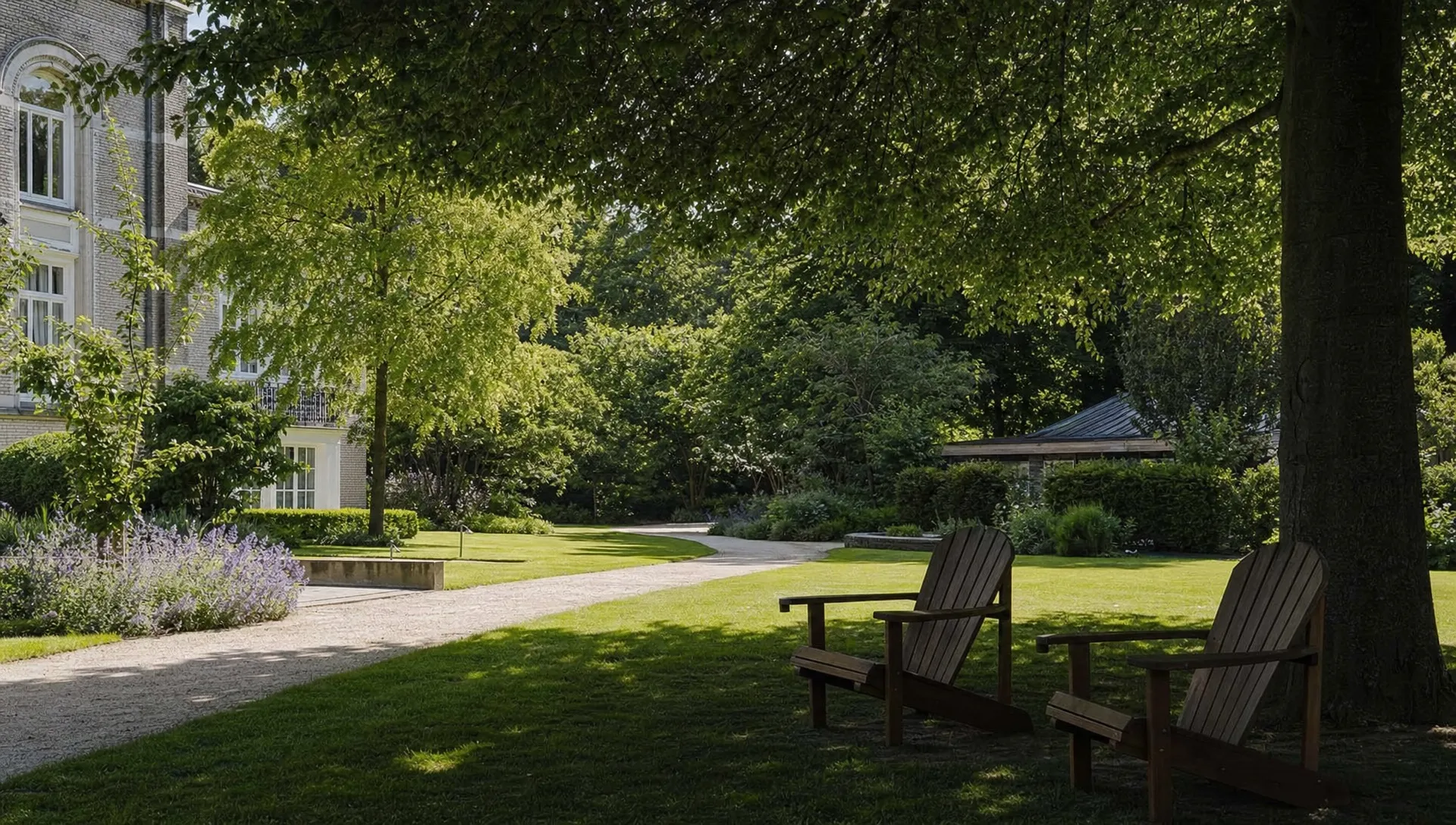 Een stille tuin bij een privé behandelcentrum met schaduwrijke stoelen, groen en veel ruimte om op adem te komen tijdens herstel.